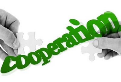 Image of two hands holding puzzle pieces connected with the word 'cooperation', representing cooperation within the disaster recovery team.