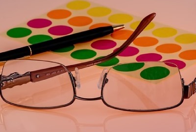 Image of eyeglasses, pen and colored tabs signifying the need for IT strategic vision.