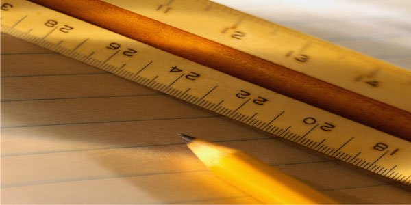 Image of rulers on a notepad demonstrating the concept of project sizing.